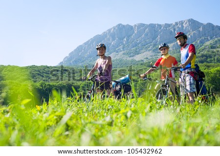Three people on mountain bikes in the background of the rocky mountains. Bike walk