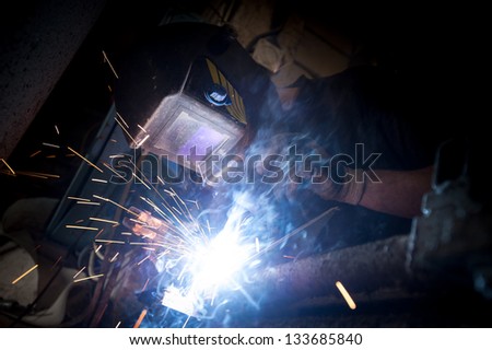 Welder at work Arc welder with welding sparks