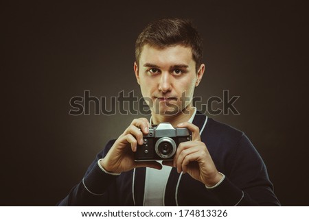 hipster photographer in studio with retro camera in hand
