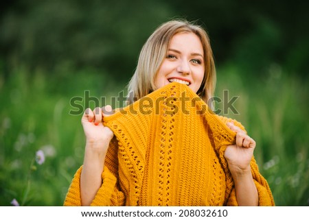 Natural portrait of a girl in a sweater outdoors