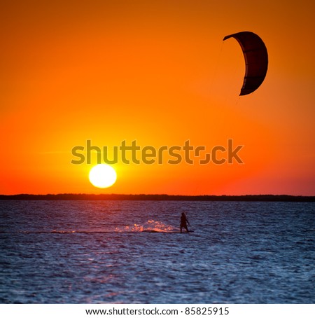 silhouette of a man with a kite at sunset