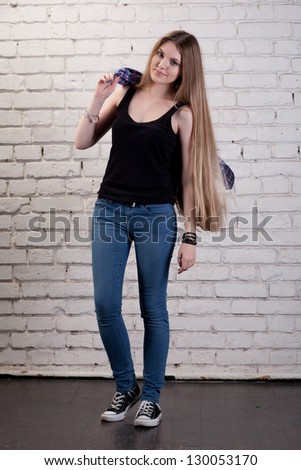 Girl posing in studio against a white brick wall