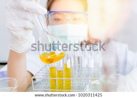 Asian women scientist with test tube making research in clinical laboratory.Science Oil pouring, Formulating the chemical for medicine,Laboratory research, dropping liquid to test tube