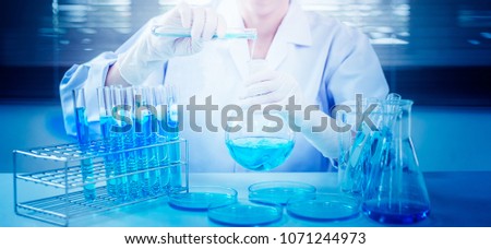 Professional distinguished Science specialist at work.Young Asian scientist with test tube making research in clinical laboratory.Innovative technologies in science and medicine