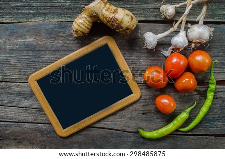 fresh herbs and spices on vintage wood background with chalkboard