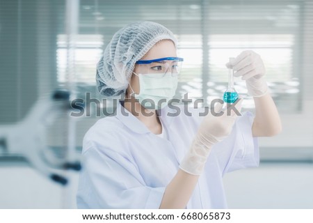 Young Asian scientist with test tube making research in clinical laboratory.Science, chemistry, technology, biology and people concept