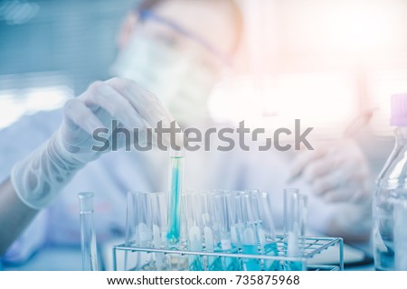 Asian women scientist with test tube making research in clinical laboratory.Science, chemistry, technology, biology and people concept