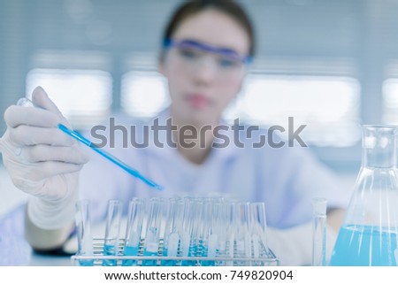 Young Asian scientist with test tube making research in clinical laboratory.Science, chemistry, technology, biology and people concept