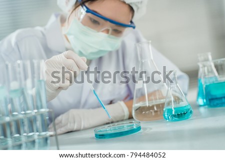 Professional distinguished Science  specialist at work.Young Asian scientist with test tube making research in clinical laboratory.Innovative technologies in science and medicine