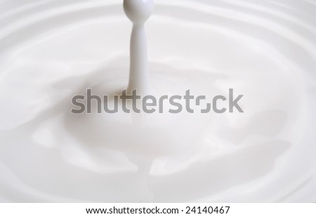 Drop of milk splashes into fresh milk