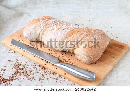 Italian bread on cutting board with bread knife