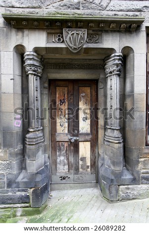 old carved stone door with graffiti