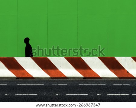 shape of a man walking in the street under construction