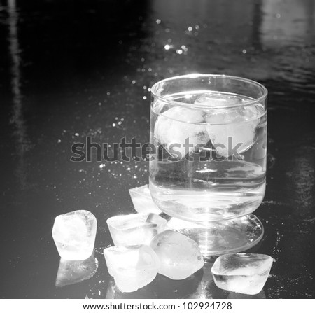 ice cubes on an iced water surface and cup glass