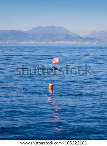 Long liner and trammel net buoy with flag pole in blue sea