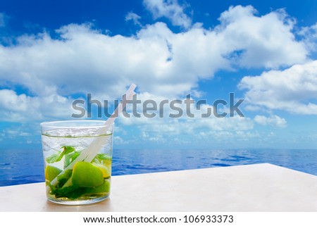 Mojito cocktail drink in summer blue calm sea and sky clouds