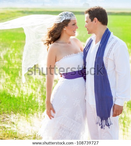 Couple in wedding day outdoor with wind on veil