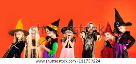 Halloween group of children girls costumes on orange background Halloween group of children girls costumes on orange background