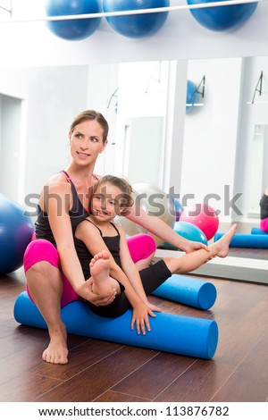 Aerobics woman personal trainer of children girl stability with foam roller