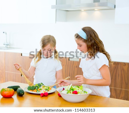Beautiful chef sisters at home kitchen preparing salad