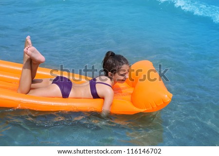 children kid girl playing in beach shore with orange floating lounge