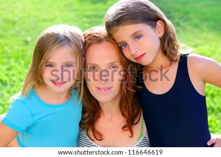 mother and two sister daughters in the garden park grass