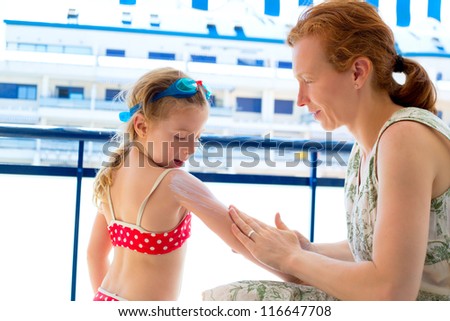 children girl with mother applying sunscreen in summer