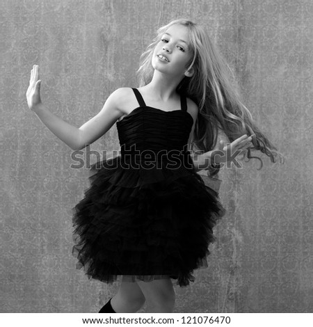 black dress kid girl dancing and twisting on vintage background