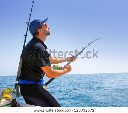 blue sea offshore fishing boat with fisherman holding rod in action