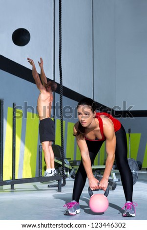 Fitness gym Kettlebell woman and jumping wall ball man  workout at gym