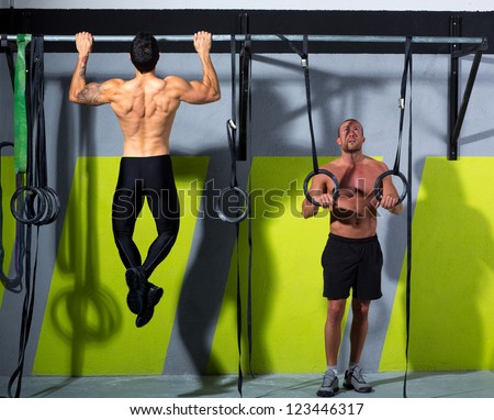Fitness dip ring and toes to bar man pull-ups men workout at gym