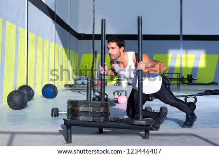 Fitness sled push man pushing weights workout exercise