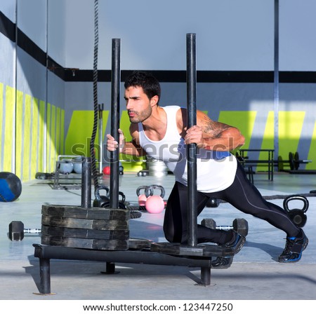 Fitness sled push man pushing weights workout exercise Fitness sled push man pushing weights workout exercise