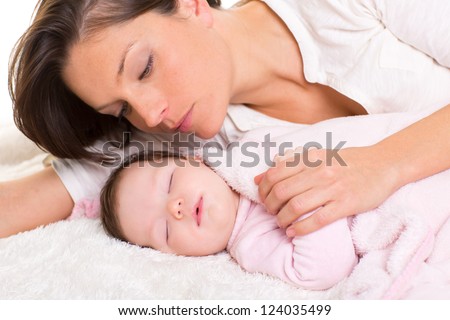 Baby girl sleeping with mother care near on white fur