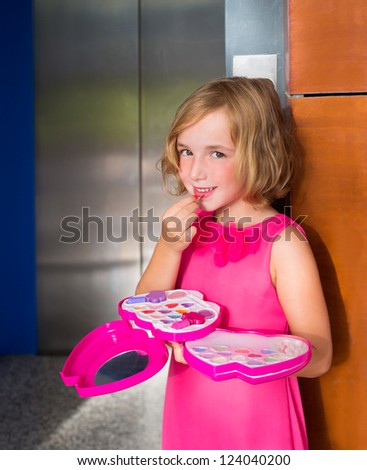 child kid girl playing with makeup lipstick in the lift door smiling happy