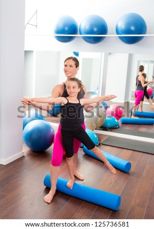 Aerobics woman personal trainer of children girl stability with foam roller