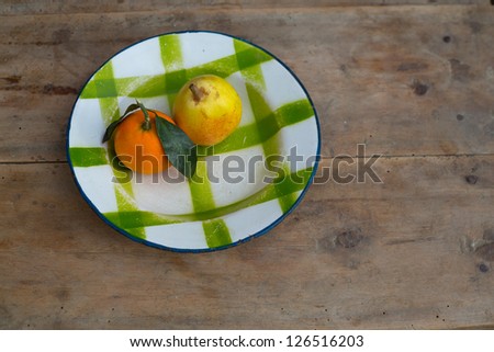 fruits tangerine and pear in vintage porcelain dish plate on retro wood table