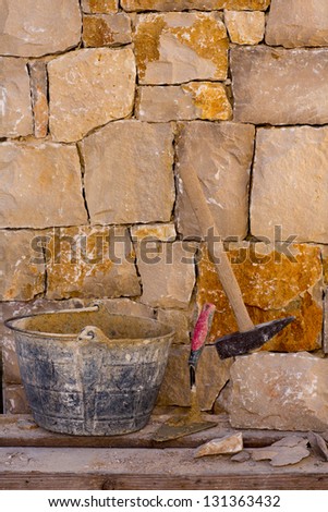 Hammer mason tools of stonecutter masonry work in a construction stone wall