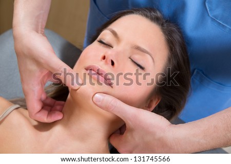 Facial tuina massge therapy on beutiful woman face by therapist hands