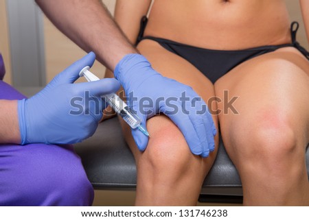 mesotherapy biopuncture doctor with syringe on woman leg