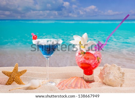 Beach tropical red and blue cocktail on caribbean white sand flower and seashell