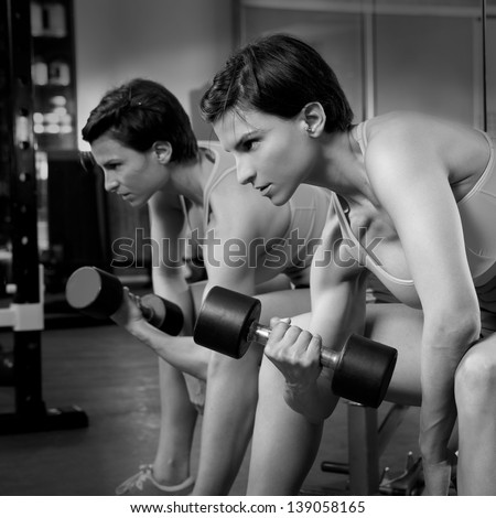 Crossfit fitness weight lifting Dumbbell woman at mirror workout exercise at gym