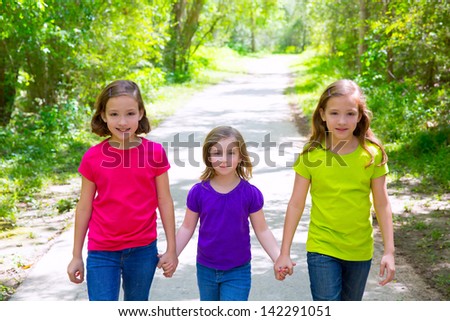 Friends and sister girls walking outdoor in forest track excursion