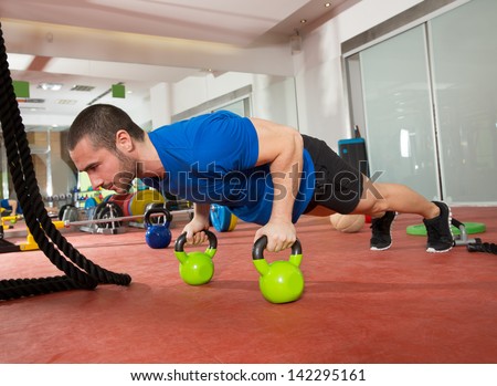 Crossfit fitness man push ups Kettlebells pushup exercise at gym workout