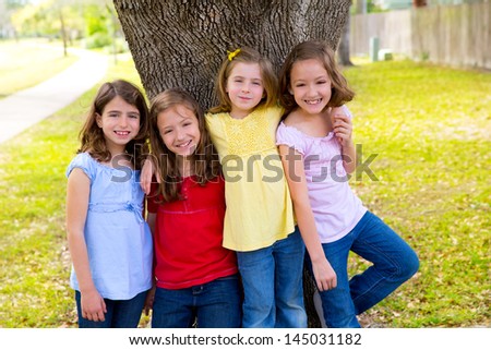 Children group friend girls friends playing on tree trunk at the park outdoor