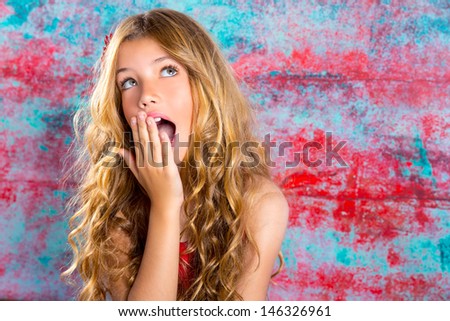 Blond kid girl surprised expression hands in face gesture