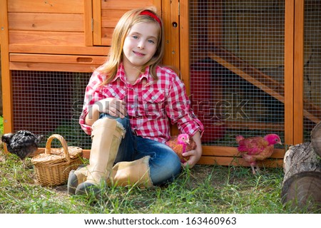 breeder hens kid girl rancher blond farmer playing with chicks in chicken tractor coop