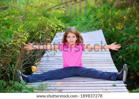 Kid girl in autumn deck smiling with braces open arms and legs outdoor