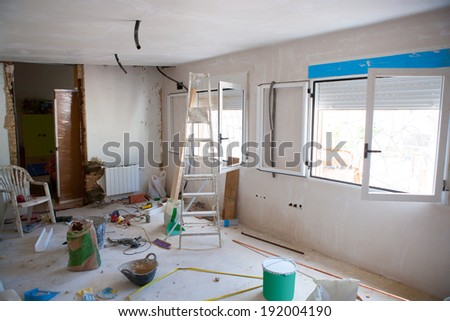 House indoor improvements in a messy room construction with plaste tools and ladder