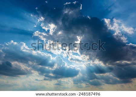 Dramatic cloudy sky clouds with real sun beams background